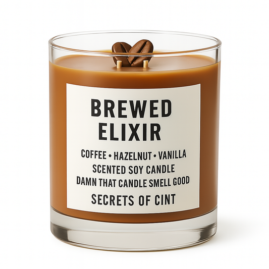 Brown soy candle labeled “Brewed Elixir” by Secrets of Cint, featuring coffee, hazelnut, and vanilla fragrance, sitting on roasted coffee beans.